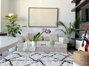 A modern living room with a sofa, coffee table, and decorative plants. - Brickell Area| Free Parking| Balcony| Rooftop Pool (Miami)