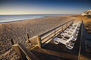 A beach with a wooden deck and white lounge chairs. - Edisto Island Luxe Family Retreat~Golf Cart Available~Pools~Close to Beach! (Edisto Island)