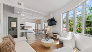 Ein modernes Wohnzimmer mit einer Couch, einem Couchtisch und einem an der Wand befestigten Fernseher.