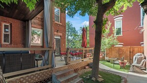 A patio area with outdoor furniture, a wooden fence, and a tree. - La Casa Vallejo - Historic Highlands home sleeps 10, walk to dining & bars (Denver)