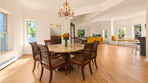 A spacious dining area with a round table, wooden chairs, and a chandelier. - La Casa Vallejo - Historic Highlands home sleeps 10, walk to dining & bars (Denver)