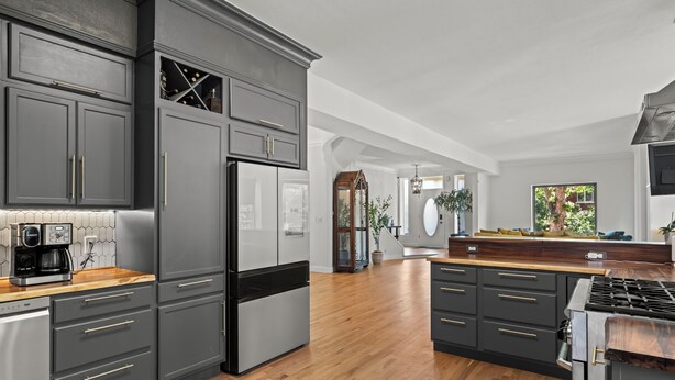 A modern kitchen with dark cabinetry, stainless appliances, and a wooden countertop. - La Casa Vallejo - Historic Highlands home sleeps 10, walk to dining & bars (Denver)
