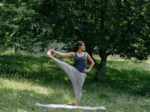 A person performing a yoga pose outdoors with trees and grass in the background. - Quinta do Outeiro 1598, Holidays or Getaways for families or groups of friends (Ruivos)