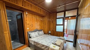 A wooden-paneled room with a bed, a door, and a window. - Serinyer Restaurant & Pansiyon (Ayvacik)