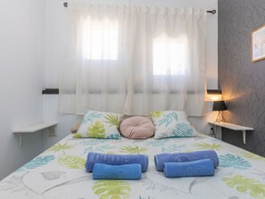 A bedroom with a bed, two bedside tables, a lamp, and a window with sheer curtains. - Marc Miami by Interhome (Miami Platja)