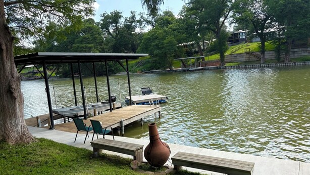 Ein Park am Seeufer mit einer Holzsteg, Bänken und einem Pavillon.