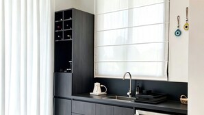A modern kitchen with a built-in oven, a sink, and a window with blinds. - NOAM by the sea Ocean View Suite #2 Adults Only (Tamarindo)
