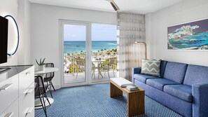 Ein modernes Hotelzimmer mit Balkon, einer Sitzecke, einem Essbereich und einem großen Gemälde.