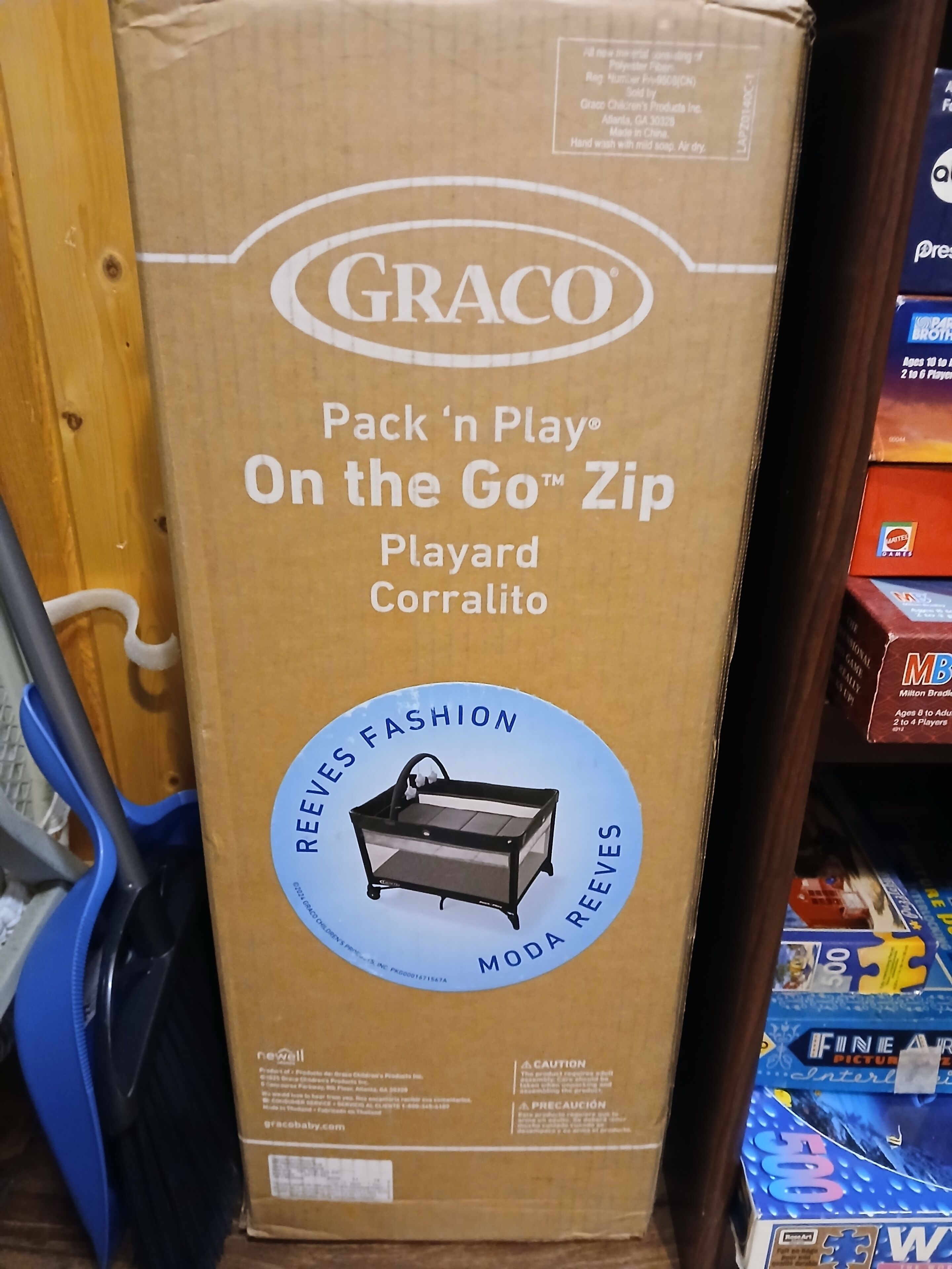 Una scatola di cartone con l'etichetta 'GRACO Pack 'n Play On the Go™ Zip Playyard Corralito'.
