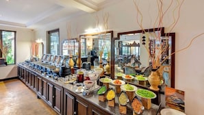 A buffet with various food stations, a long counter, and a mirror reflecting the room.