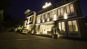 A hotel with a prominent sign, large windows, and a well-lit entrance.
