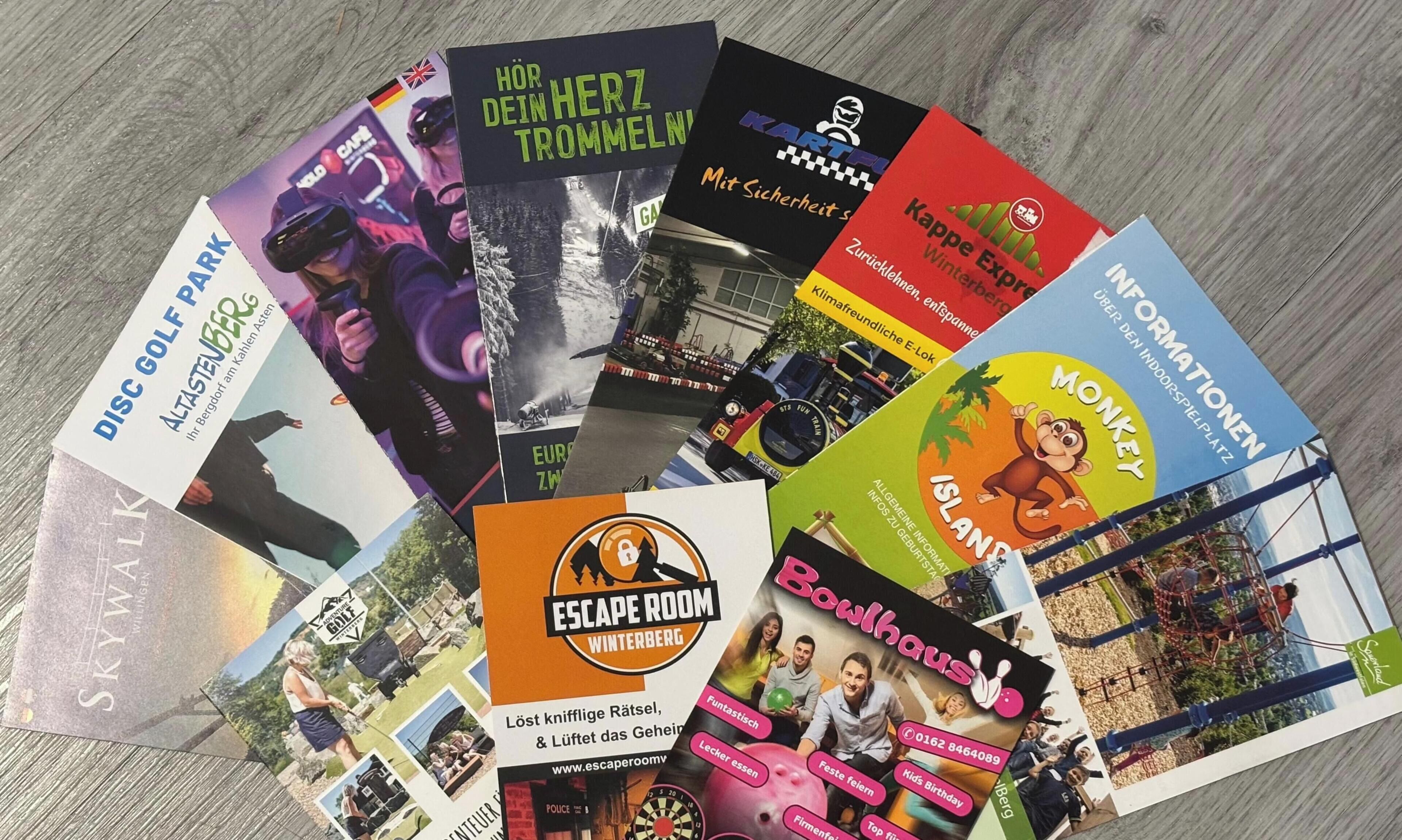 Une collection de brochures présentant diverses attractions et activités, notamment le golf sur disque, le karting, le bowling et un parc de golf sur disque.