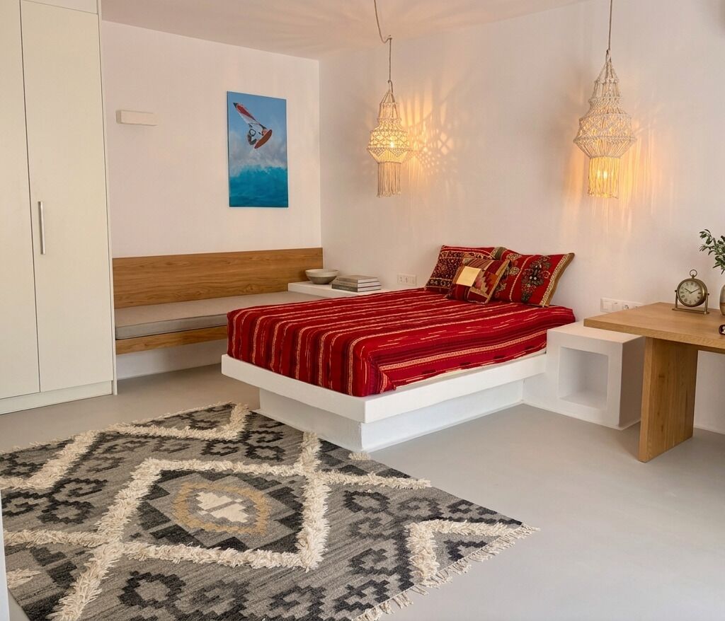 A modern bedroom with a bed, bedside tables, a rug, and wall art.