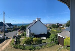 A residential area with houses, a white building with a stone base, and a clear view of the sea. - Beach house, within walking distance of the beach, with an ocean view! (Trévou-Tréguignec)