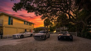 Three luxury cars parked in front of a yellow building with a white fence. - Beachfront Cottage Sleeps up to 4 Unit A (Indian Rocks Beach)