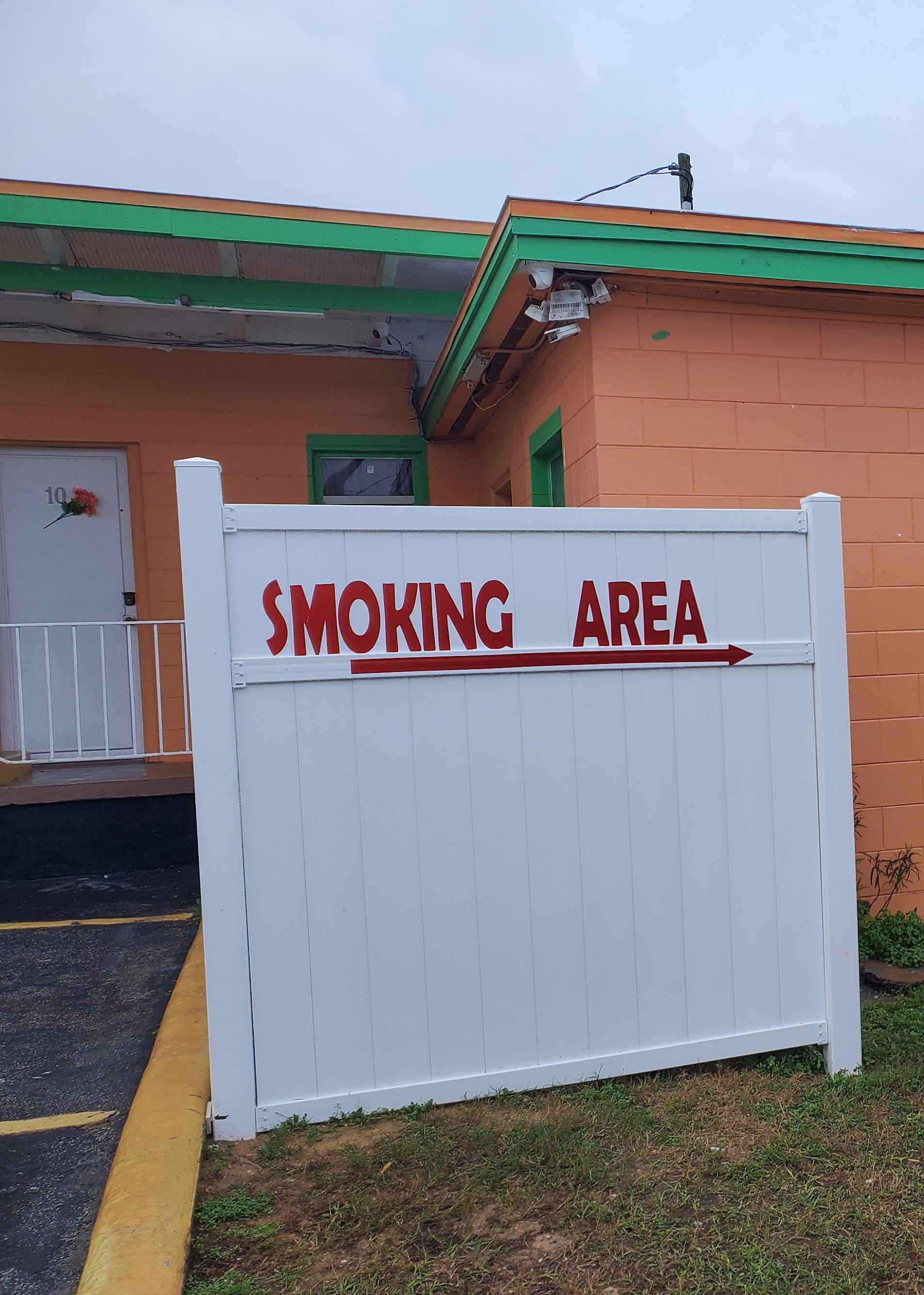 Una puerta blanca con la leyenda 'SMOKING AREA' escrita en rojo.
