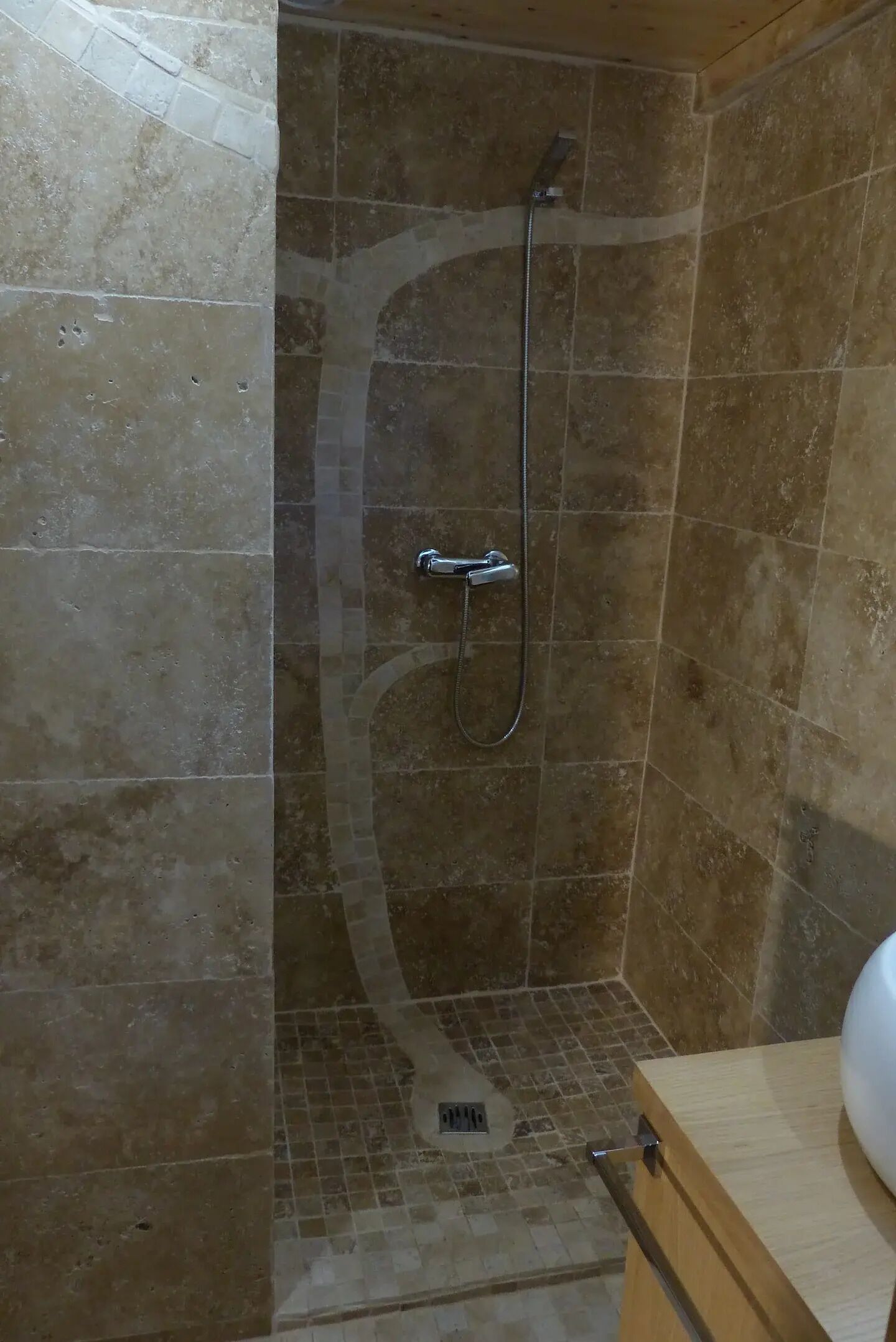A shower area with a tiled wall and a showerhead.