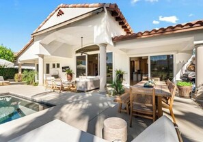 A house with a pool, outdoor seating, and a covered patio area. - Palm Desert luxury 3-bed+ home. Golf Cart, pickleball etc, in Rancho La Quinta (La Quinta)