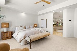 A modern bedroom with a bed, bedside lamps, a bench, and a ceiling fan. - Palm Desert luxury 3-bed+ home. Golf Cart, pickleball etc, in Rancho La Quinta (La Quinta)