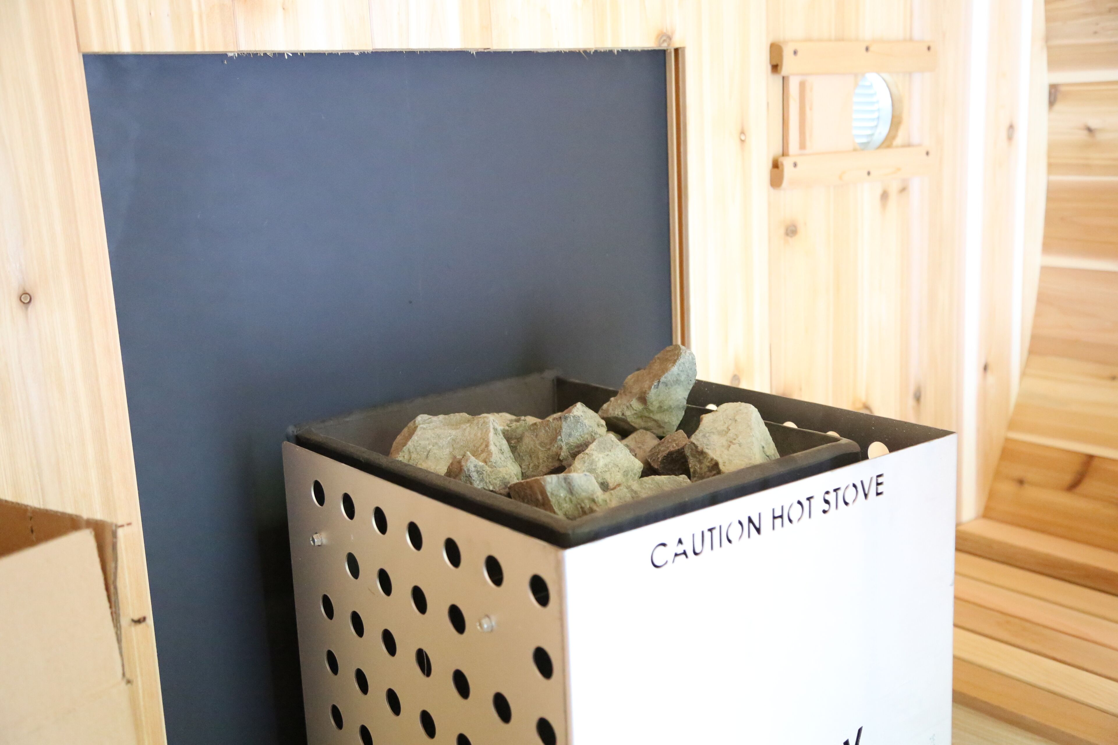Un panneau d’avertissement sur une cuisinière chaude, un mur en bois et un sauna.