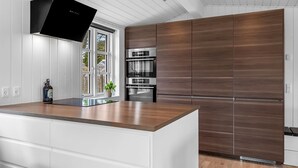 Una cucina moderna con una grande isola, elettrodomestici integrati e una finestra con vista.