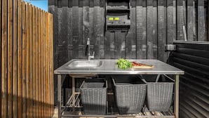 Una cucina con lavandino, finestra e una recinzione in legno.