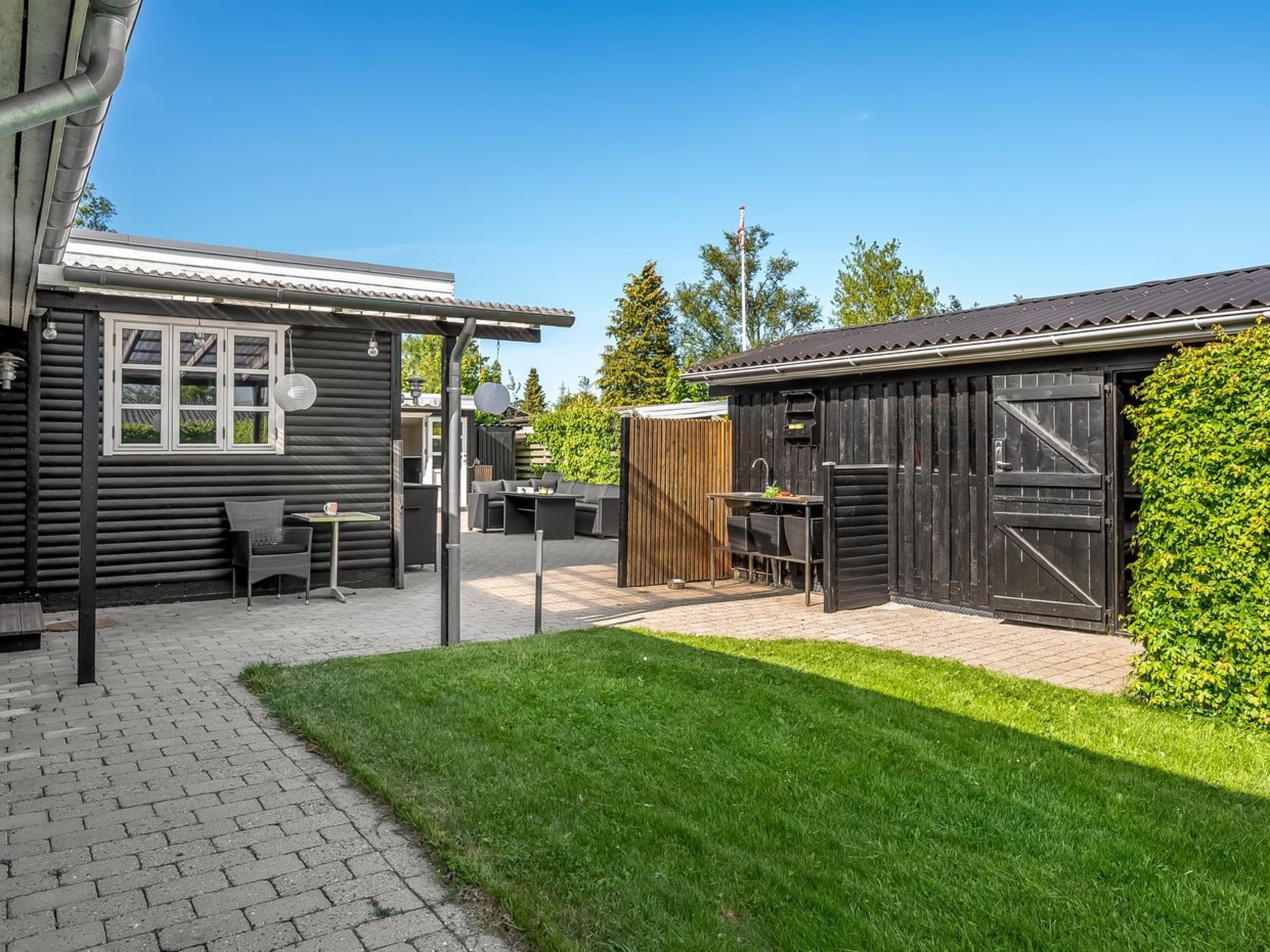A patio area with outdoor furniture, a grill, and a shed.