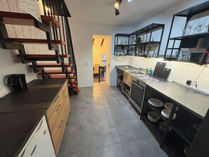 Eine moderne Küche mit Treppe, Essbereich und Kücheninsel.