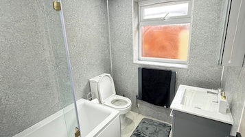 Kombinasi shower/bathtub, bathtub besar, dan handuk