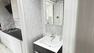 Kombinasi shower/bathtub, bathtub besar, dan handuk