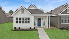 A single-story house with a front porch, a blue door, and a small front yard. - Heights Hideaway is your perfect 3BD/2BA Bentonville basecamp! (Bentonville)