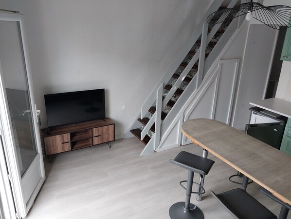 A modern kitchen with a wooden countertop, a bar stool, and a staircase with a patterned railing. - One-bedroom apartment at La Péniche de Thau with a large terrace (Marseillan)