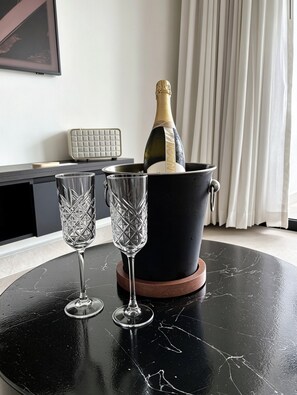 A black marble table with a champagne bottle and two crystal glasses. - NOAM by the sea Ocean View Suite #1 Adults Only (Tamarindo)