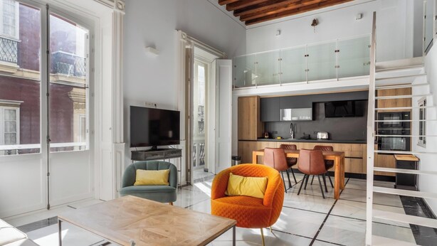 Een modern appartement met woonkamer, eethoek, keuken en een balkon.