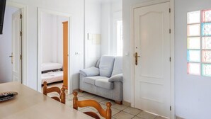 Ein Zimmer mit Esstisch, Stühlen, einer Couch und einem Bett.