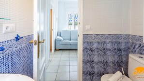 Ein Badezimmer mit gefliestem Boden, Toilette und Waschbecken.