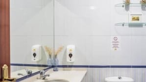 Une salle de bain équipée d’un lavabo, de toilettes et de distributeurs de savon pour les mains.