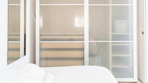 A bedroom with a bed, a wardrobe, and a sliding glass door. - Charming Penthouse in the Heart of Cádiz (Ciudad de Cádiz)