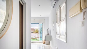 A hallway with a view to a balcony, a door, and a wall-mounted air conditioning unit. - Charming Penthouse in the Heart of Cádiz (Ciudad de Cádiz)