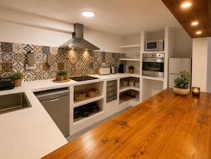 Una cocina moderna con encimera de madera, electrodomésticos integrados y salpicadero con diseño.