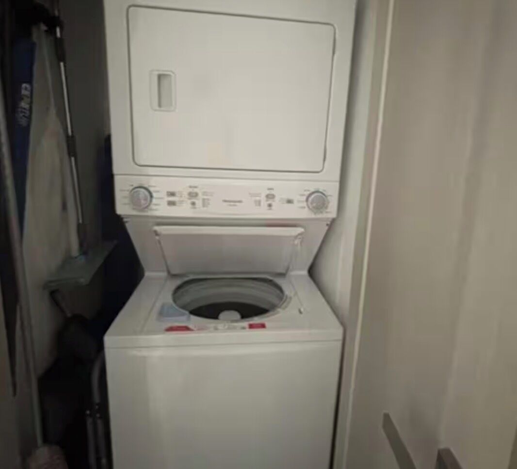 Una lavadora blanca compacta de carga frontal, con panel de control y puerta.