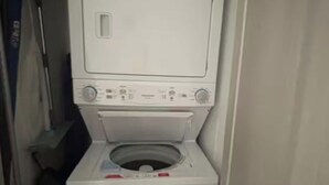 Eine kompakte, weiße Waschmaschine mit Frontlader, Bedienfeld und Tür.