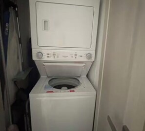 Eine kompakte, weiße Waschmaschine mit Frontlader, Bedienfeld und Tür.