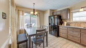 A kitchen with a dining table, chairs, a refrigerator, and cabinets. - Family Pool Retreat in Spring , Houston  4BR Private Pool  Sleeps 8 (Spring)