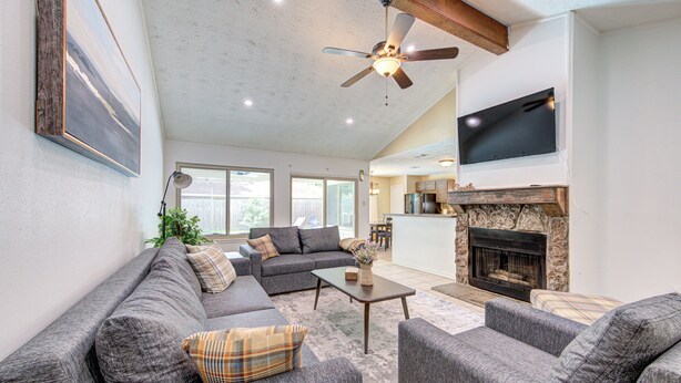 A living room with a sofa set, a fireplace, and a ceiling fan. - Family Pool Retreat in Spring , Houston  4BR Private Pool  Sleeps 8 (Spring)