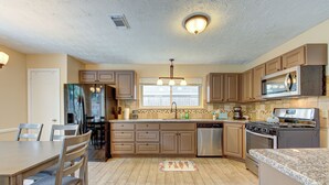 A kitchen with a dining table, chairs, a refrigerator, a microwave, a stove, and a dishwasher. - Family Pool Retreat in Spring , Houston  4BR Private Pool  Sleeps 8 (Spring)