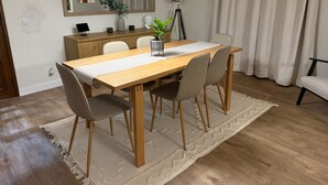 A dining area with a wooden table, four chairs, a rug, a mirror, a plant, and a lamp. - Family Villa with Jacuzzi, Large Garden & Free Parking (Quinta do Conde)