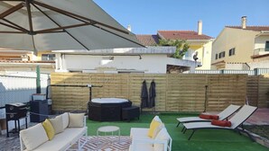A patio with outdoor furniture, a fire pit, and a wooden fence. - Family Villa with Jacuzzi, Large Garden & Free Parking (Quinta do Conde)