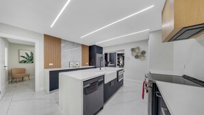 Une cuisine moderne dotée d’un îlot central, d’appareils électroménagers intégrés et d’un design épuré.