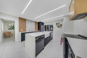 Eine moderne Küche mit Kochinsel, integrierten Geräten und stilvollem Design.